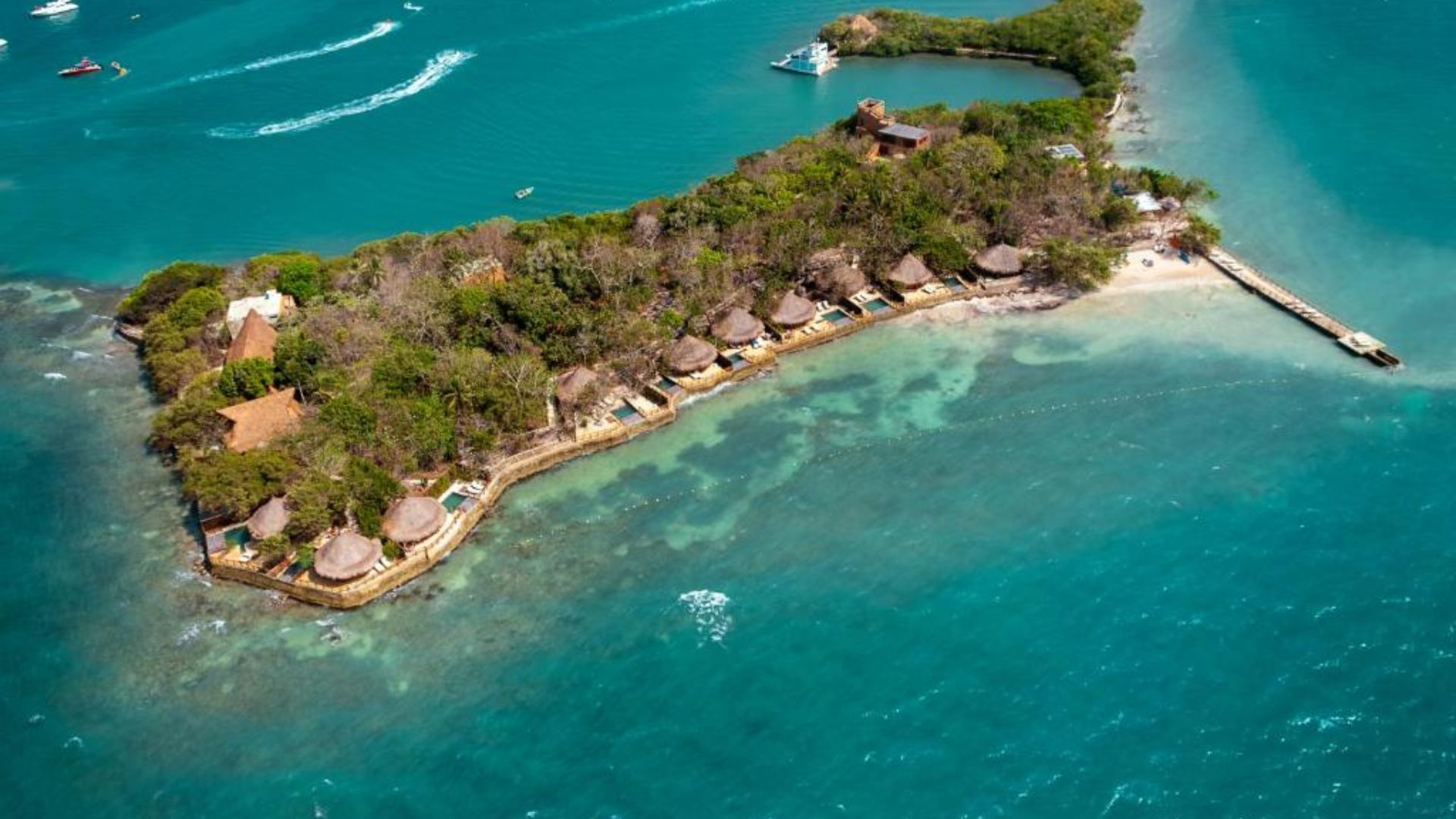 A serene island with thatched huts and a small boat surrounded by vast ocean waters.