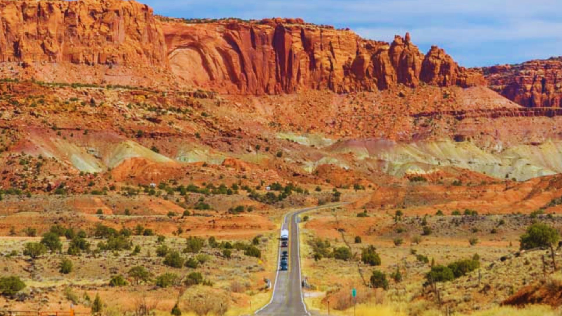 Scenic desert road leading to Capitol Reef National Park, showcasing vibrant landscapes and natural beauty.