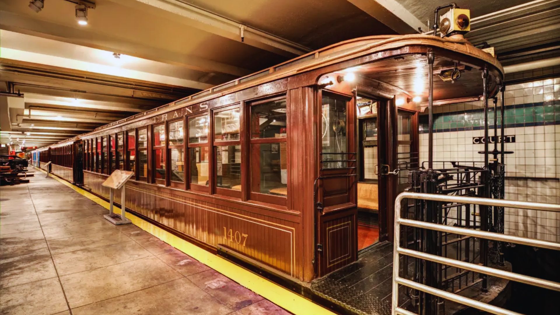 An old-fashioned trolley car parked at a train station, showcasing vintage design and historical charm.