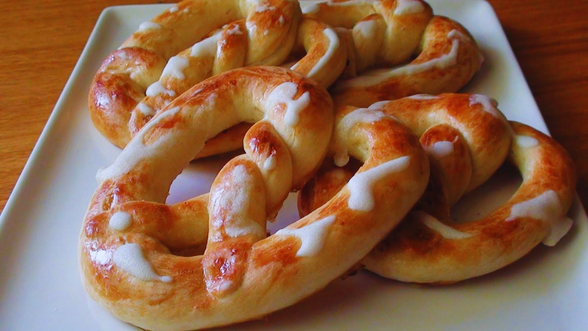 A plate of pretzels drizzled with sweet icing, showcasing a tempting dessert option.