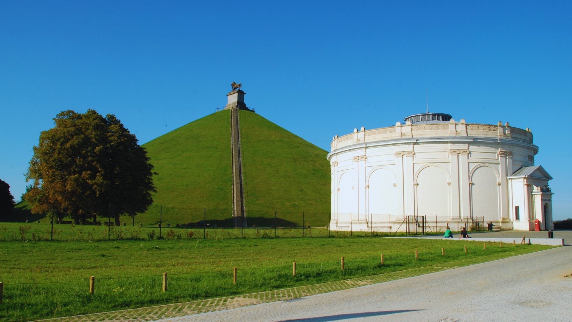 A large white building with a modern architectural design against a clear blue sky.