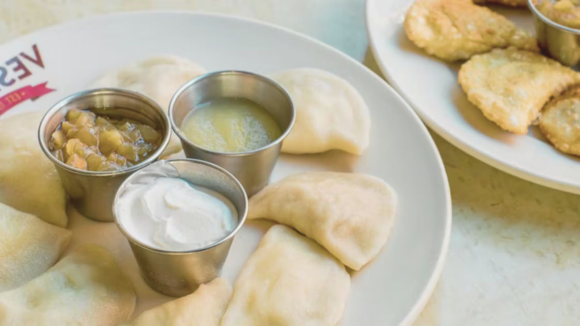 A plate featuring a variety of dumplings alongside assorted food items, showcasing diverse textures and colors.