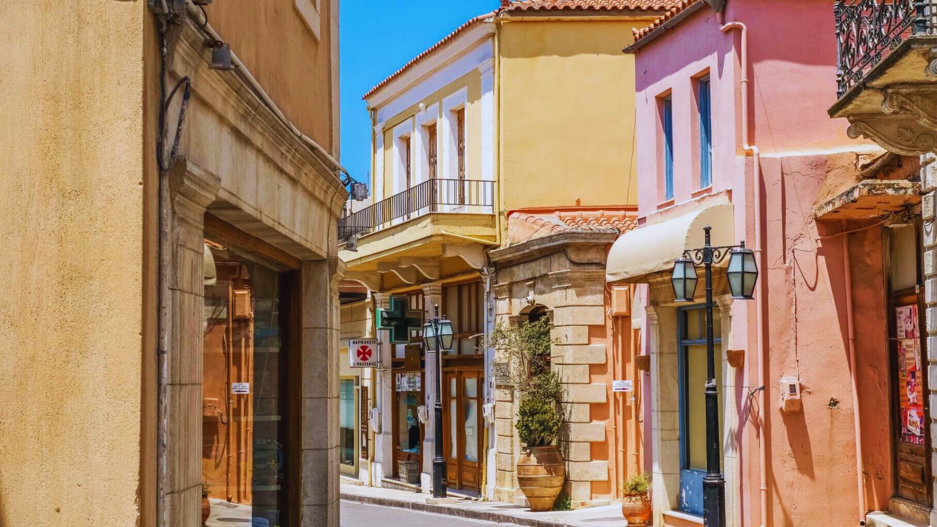 A picturesque narrow street featuring colorful buildings and a sunny blue sky.