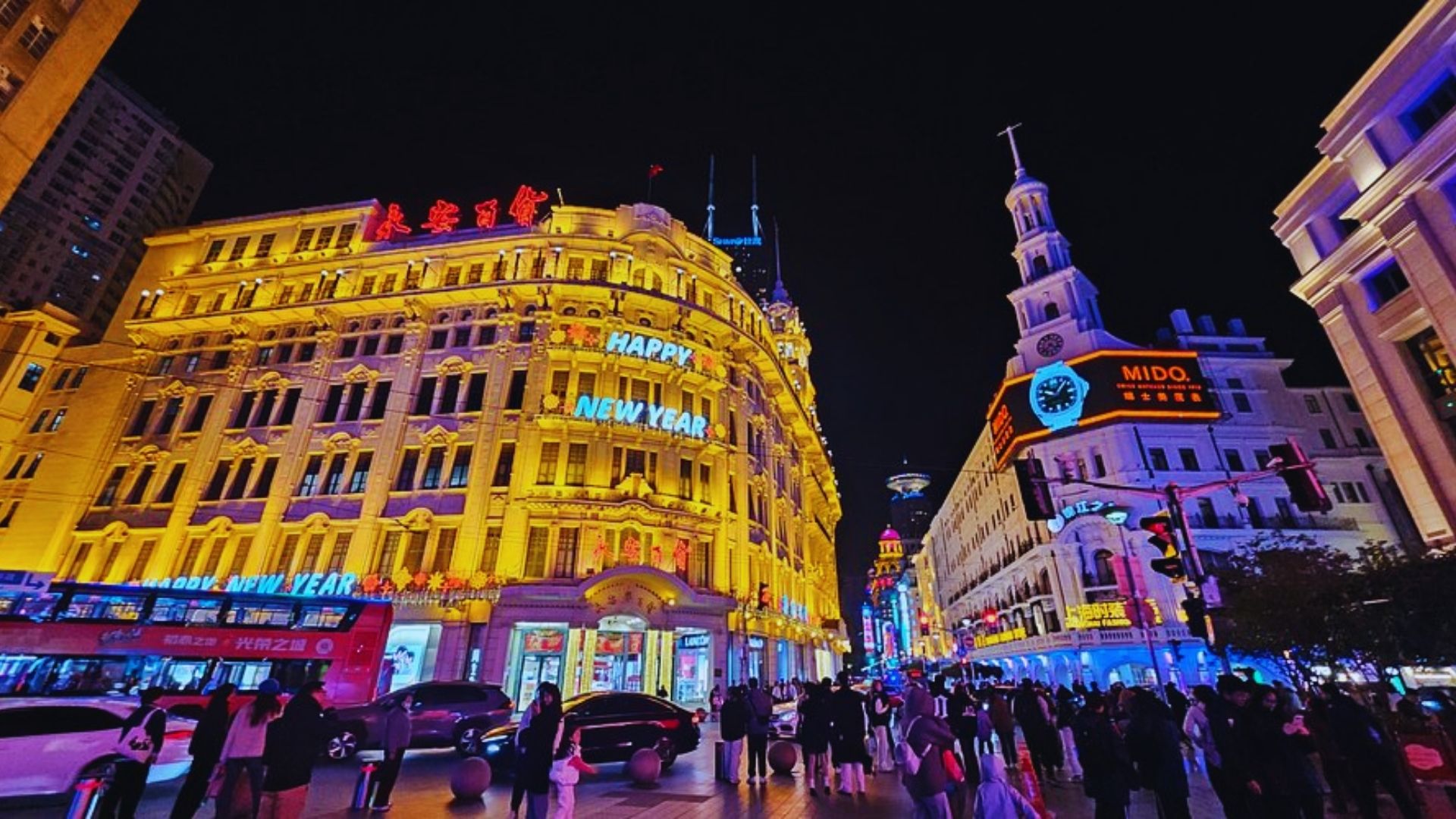 Vibrant night scene in Shanghai, showcasing a bustling shopping street filled with people and illuminated storefronts.