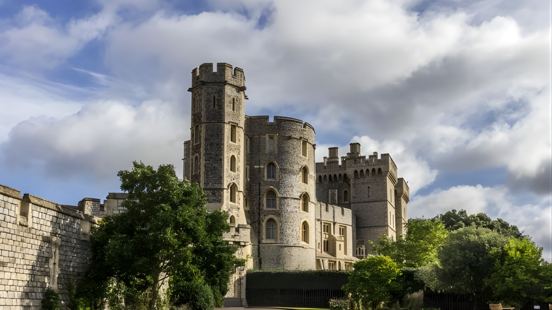 Historic stone castle with round towers and battlements under a partly cloudy sky, surrounded by lush green trees, exuding a majestic, timeless aura.