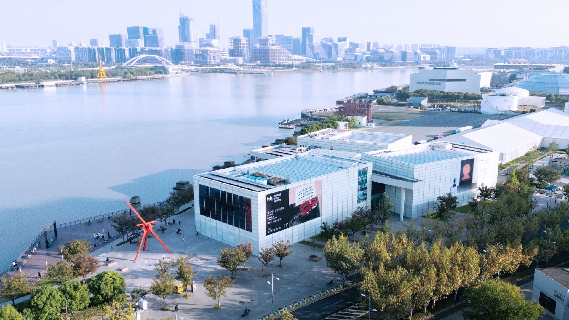 Aerial view of Shanghai showcasing its skyline, including skyscrapers and the Huangpu River winding through the city.
