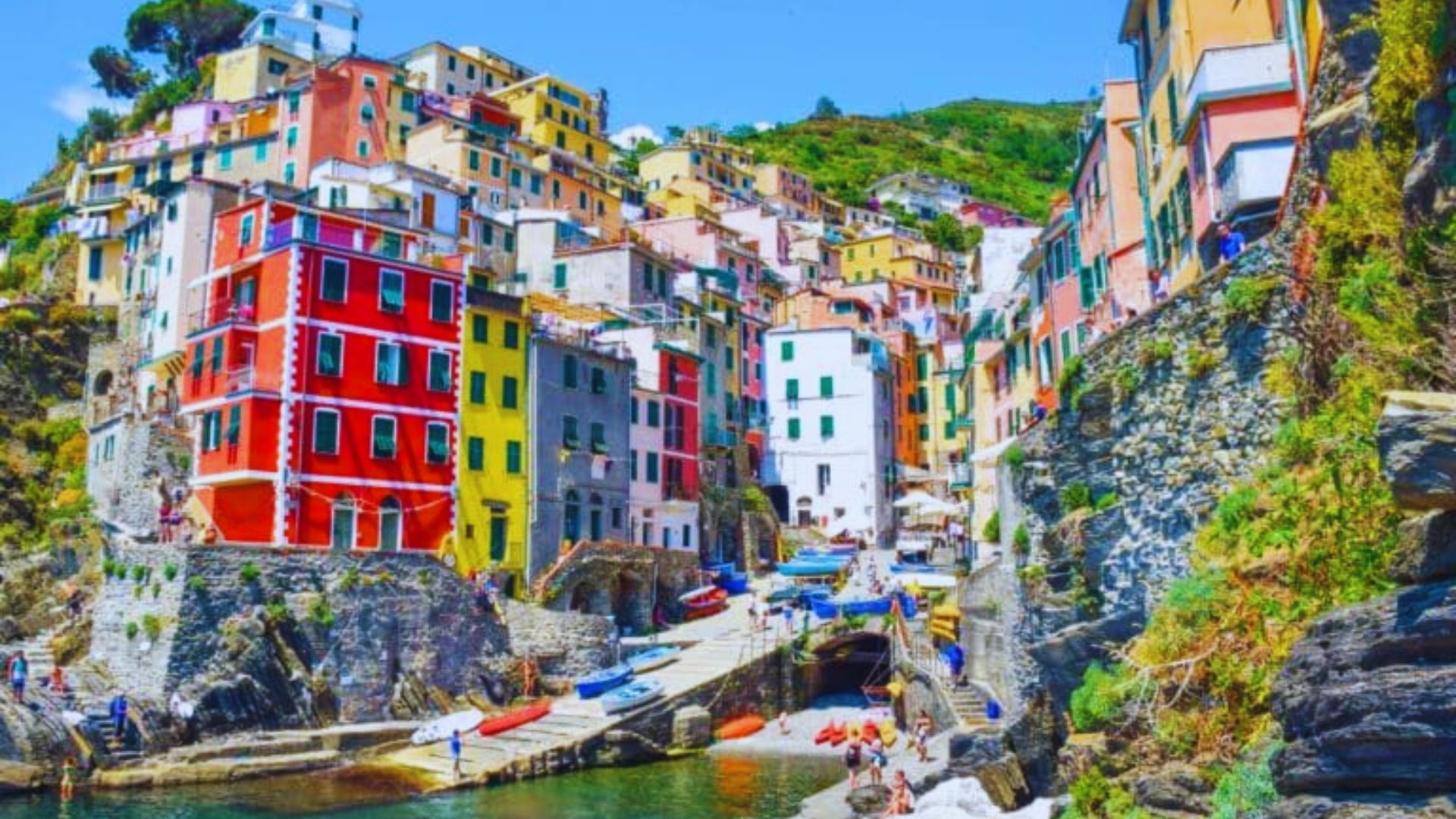 Colorful houses perched on a cliffside, showcasing vibrant hues against a scenic backdrop.