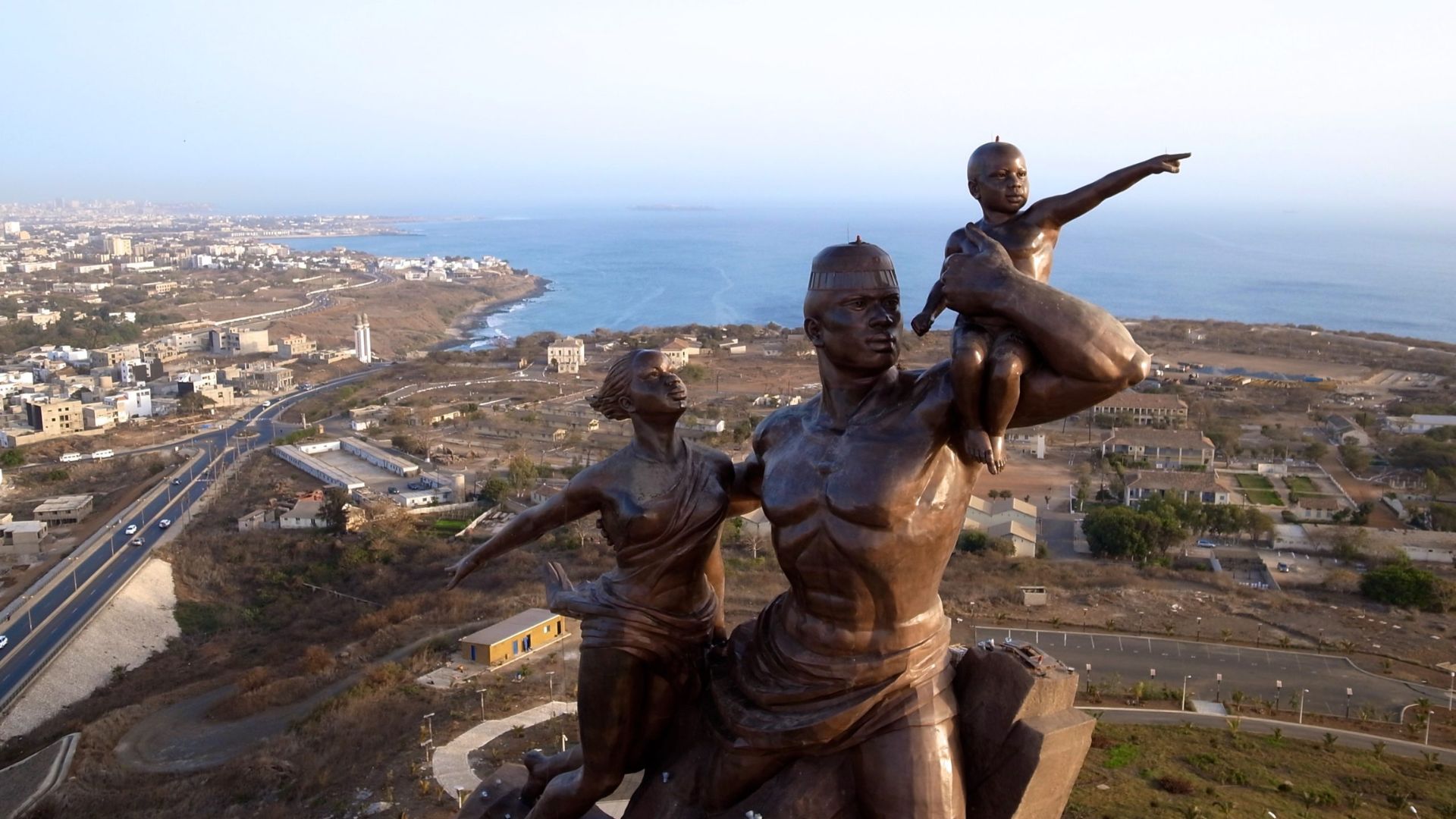 A statue depicting a woman and child, with a man standing atop them, symbolizing protection and family unity.
