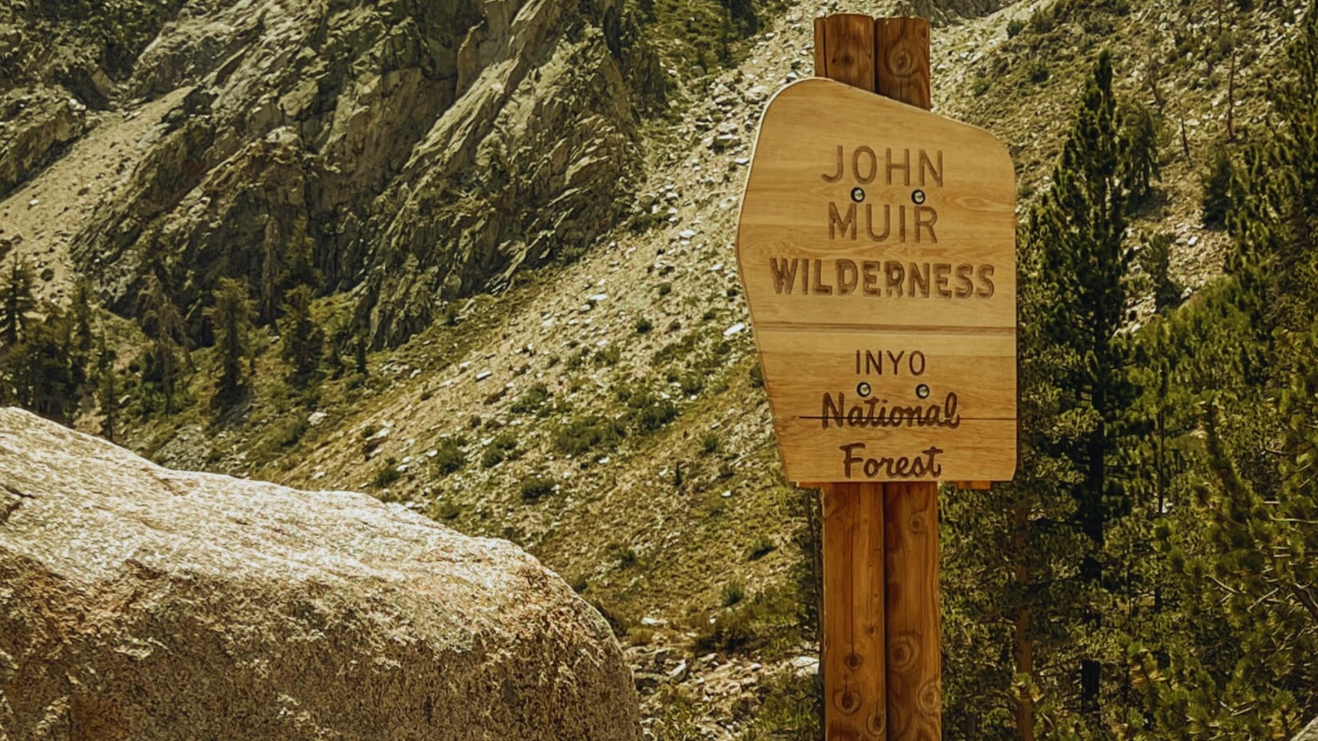 A sign reading "John McCain Wilderness" stands amidst a natural landscape, indicating the protected area.