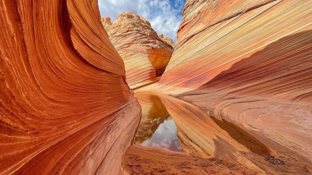 Photograph of Antelope Canyon by Jimmy Kirk, showcasing vibrant rock formations and light beams illuminating the canyon walls.