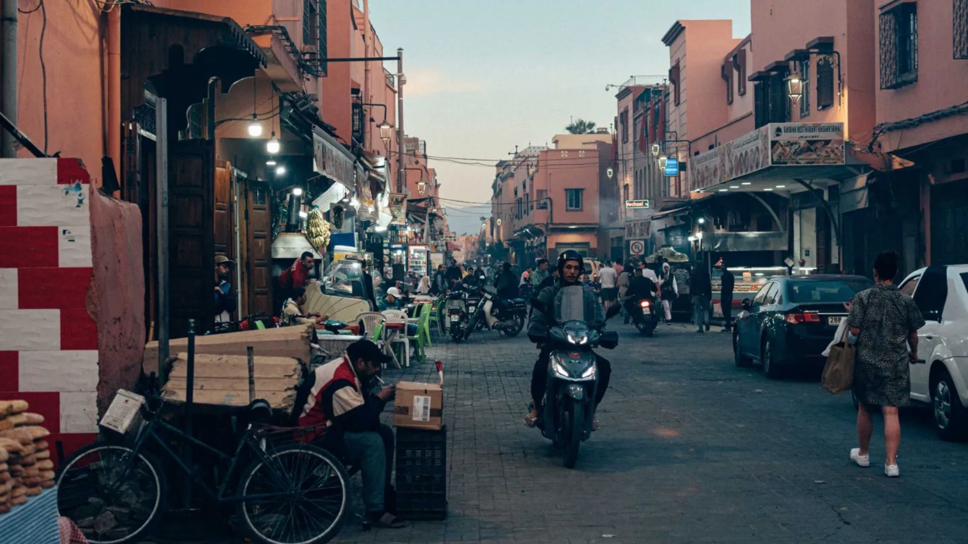 A busy street scene with pedestrians walking and cyclists riding alongside each other.