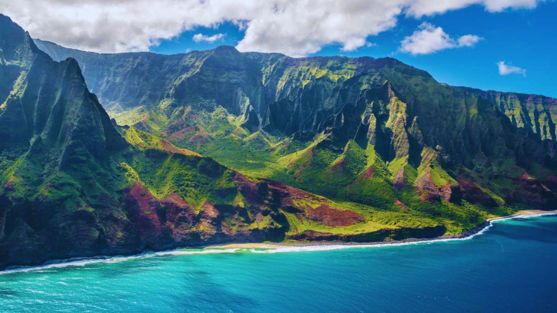 Scenic view of Na Pali Coast in Kauai, Hawaii, showcasing dramatic cliffs and lush greenery against a blue sky.