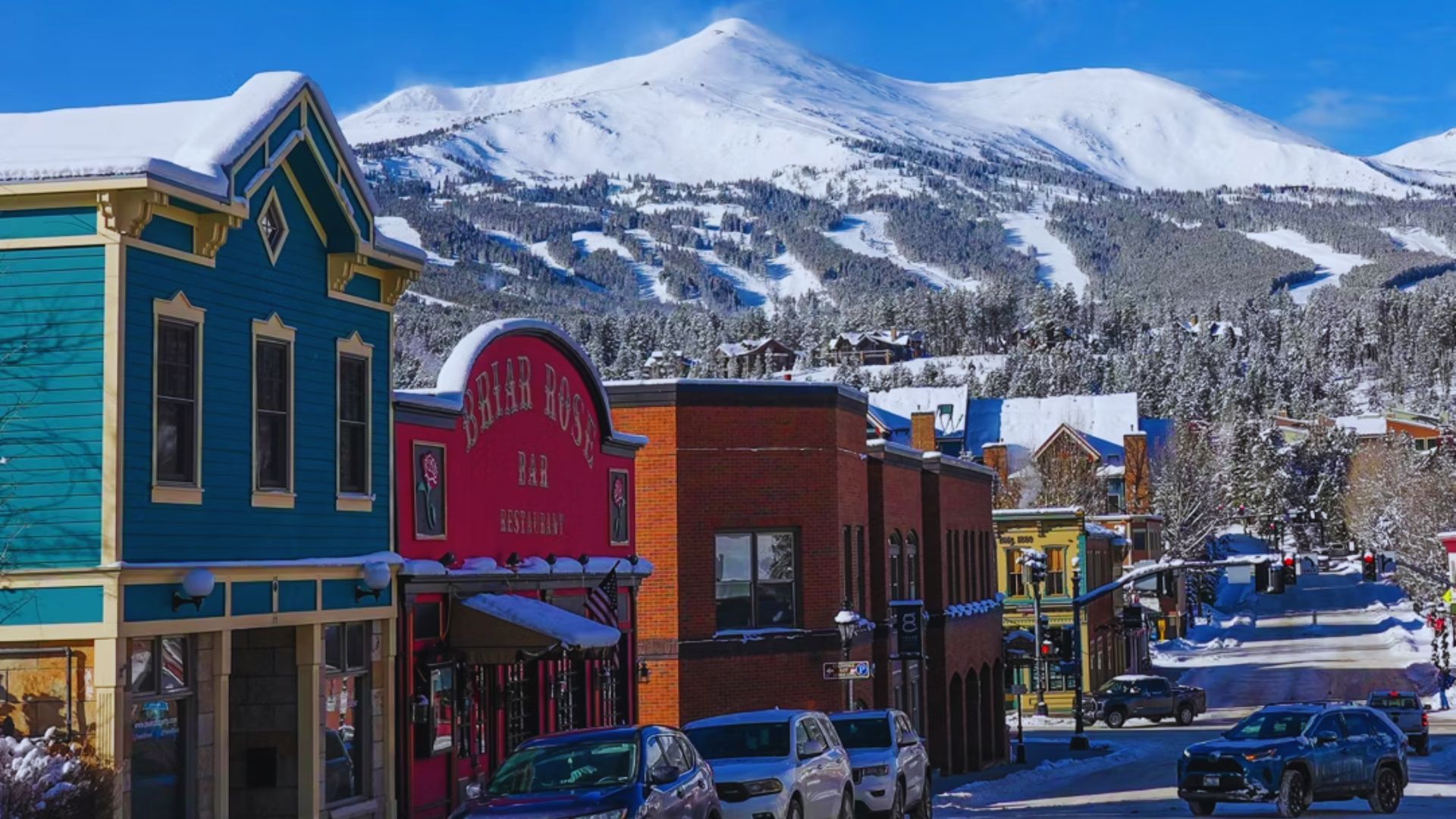 A picturesque town with snow-covered mountains rising majestically in the background.