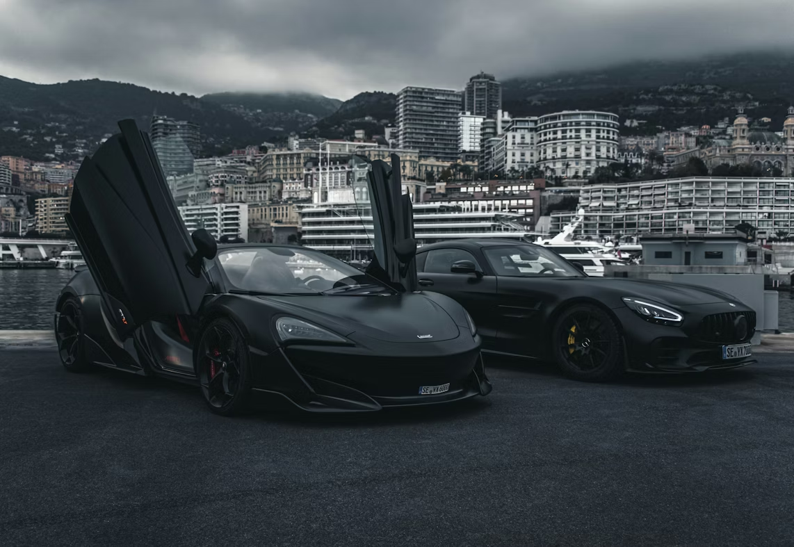 A pair of black sports cars parked next to each other, showcasing their glossy finishes.