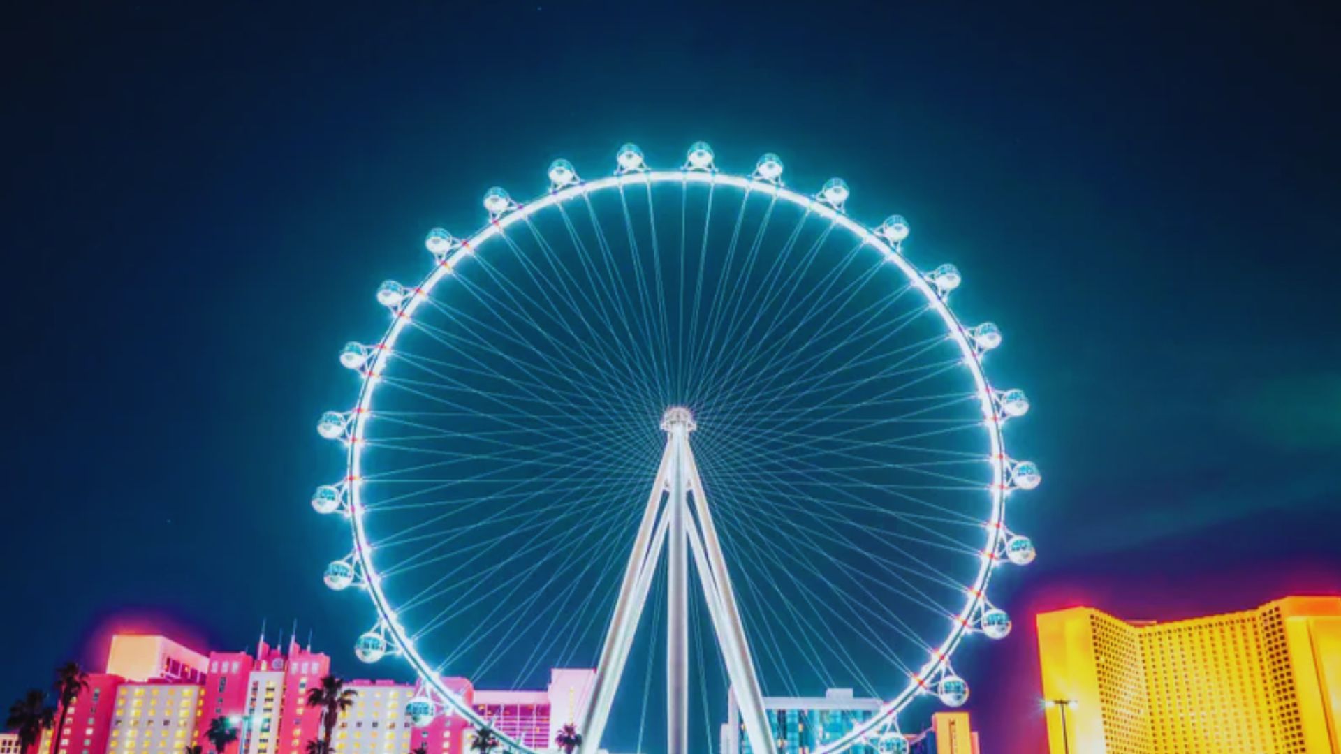 The Las Vegas Ferris wheel illuminated at night, showcasing vibrant lights against a dark sky.