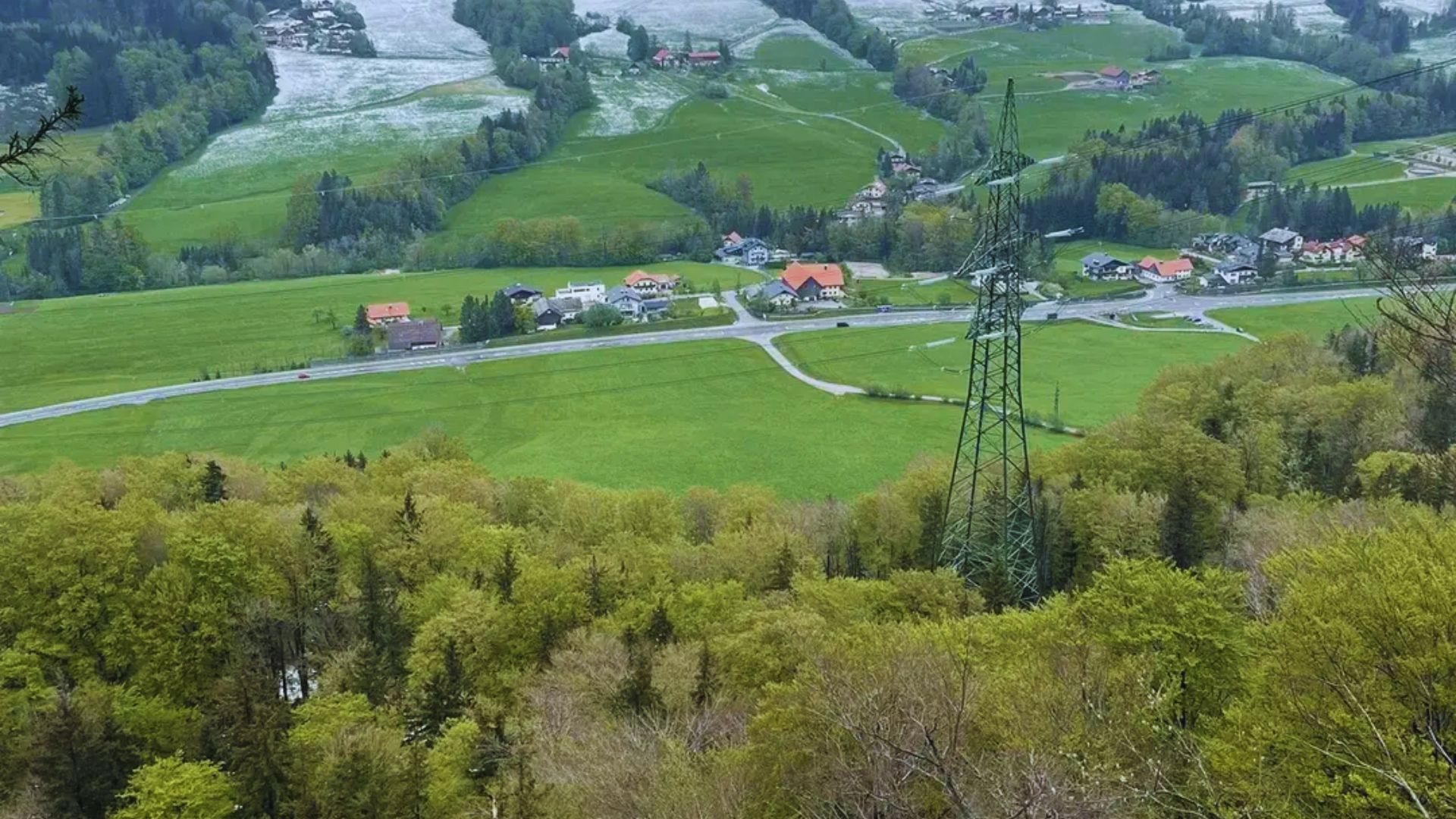 A vibrant green valley with charming houses and trees, illustrating a serene countryside setting.
