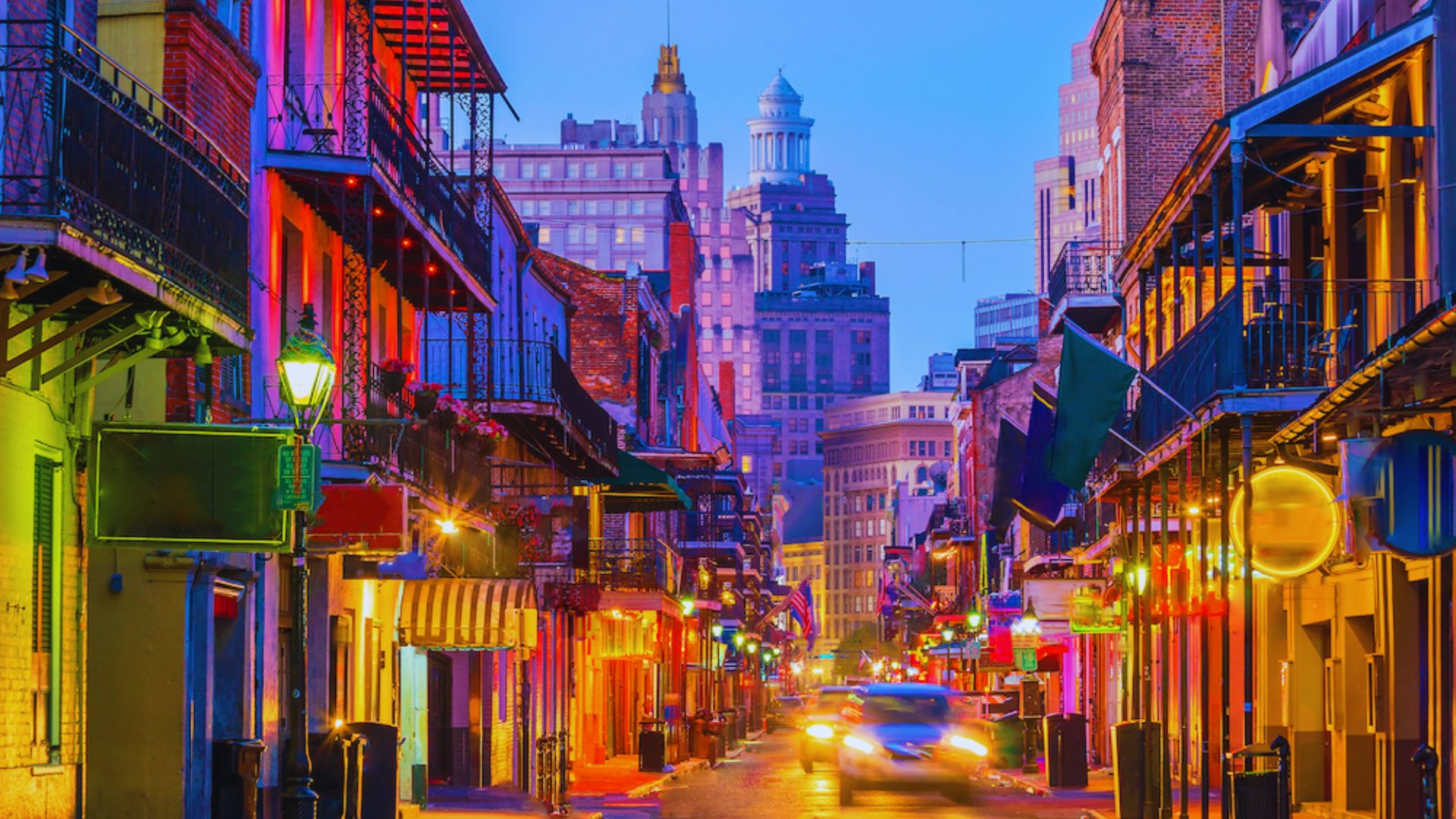 A picturesque New Orleans street showcasing colorful architecture and cars amidst a sunny atmosphere.