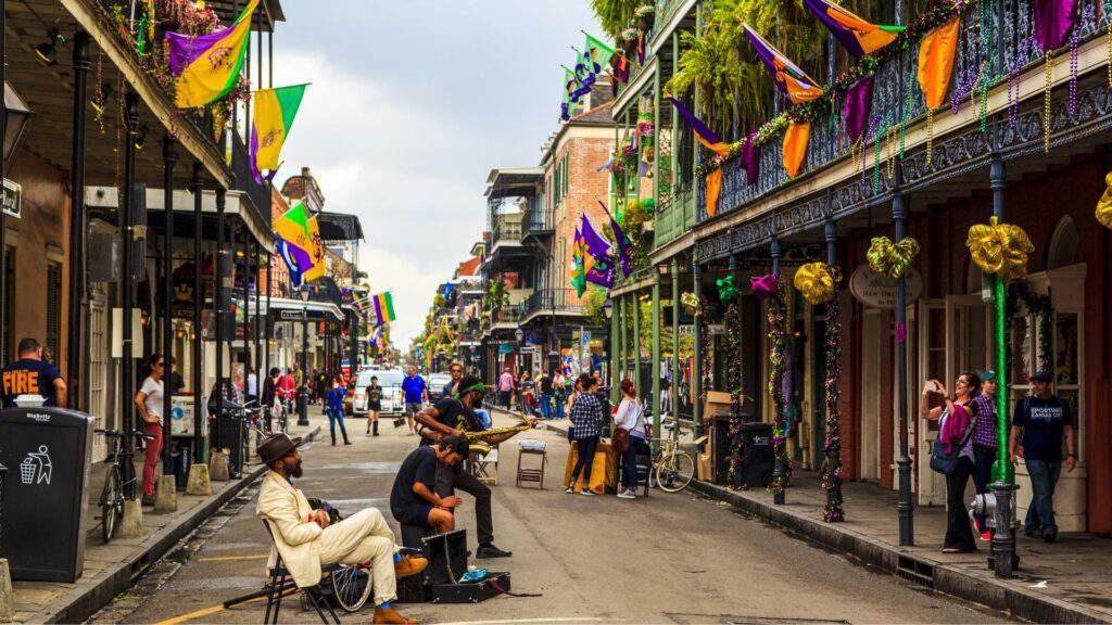 A group of people sitting on a city sidewalk, engaged in conversation and enjoying the urban environment around them.
