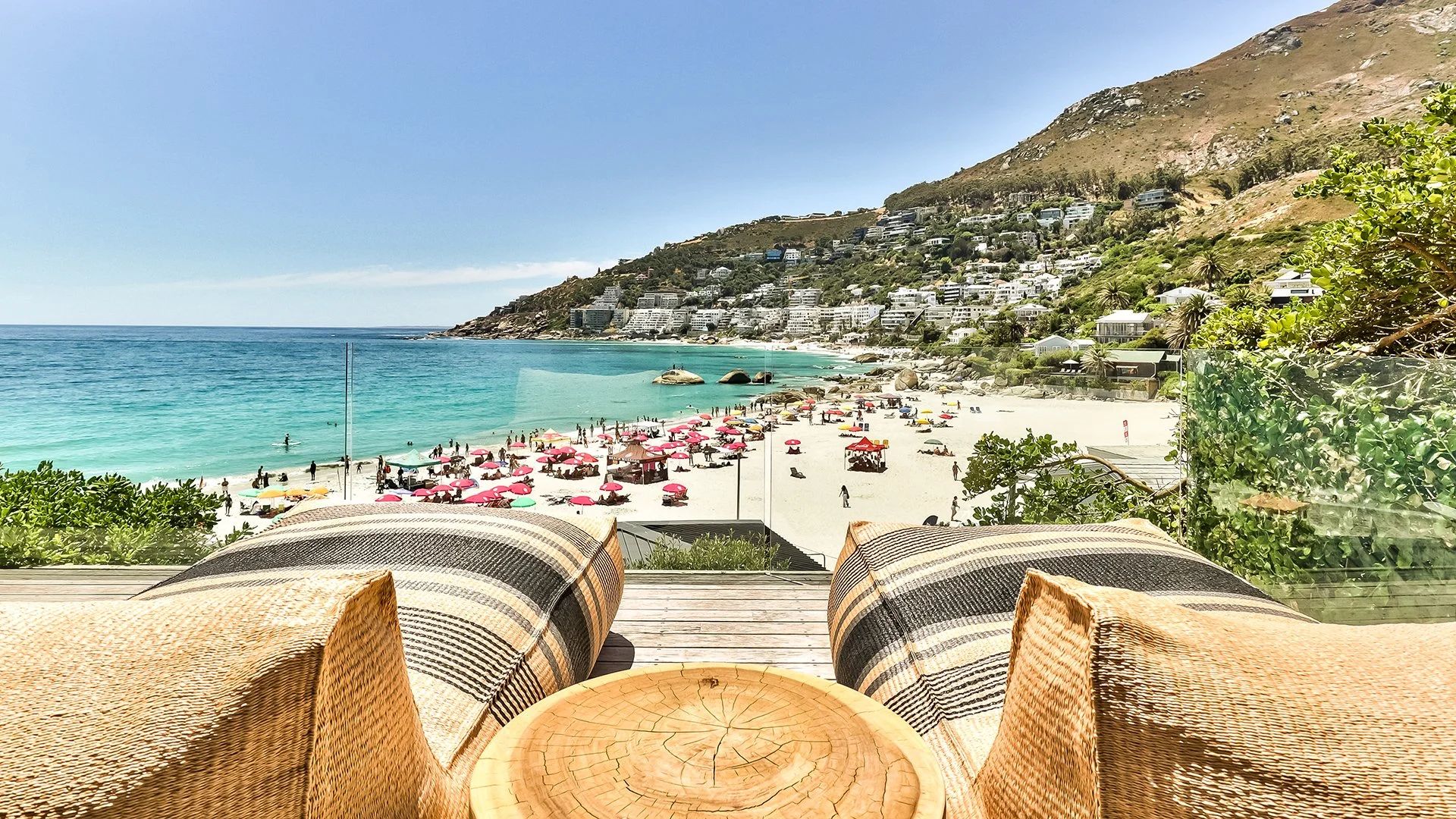 Scenic view of the beach at the Cape Town hotel, featuring golden sand and gentle waves under a clear blue sky.