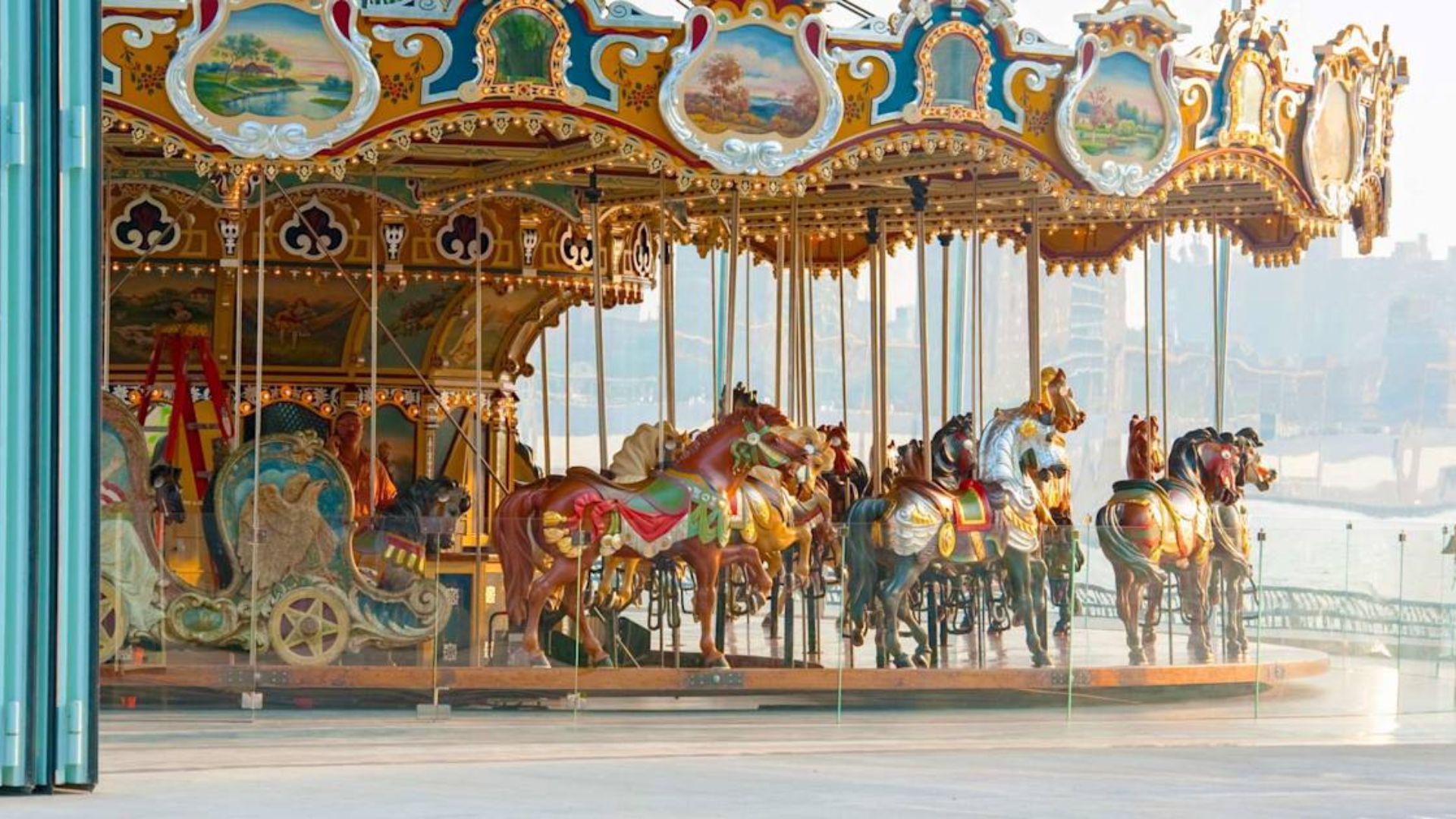 A colorful carousel stands in front of a large building, inviting visitors to enjoy a ride.