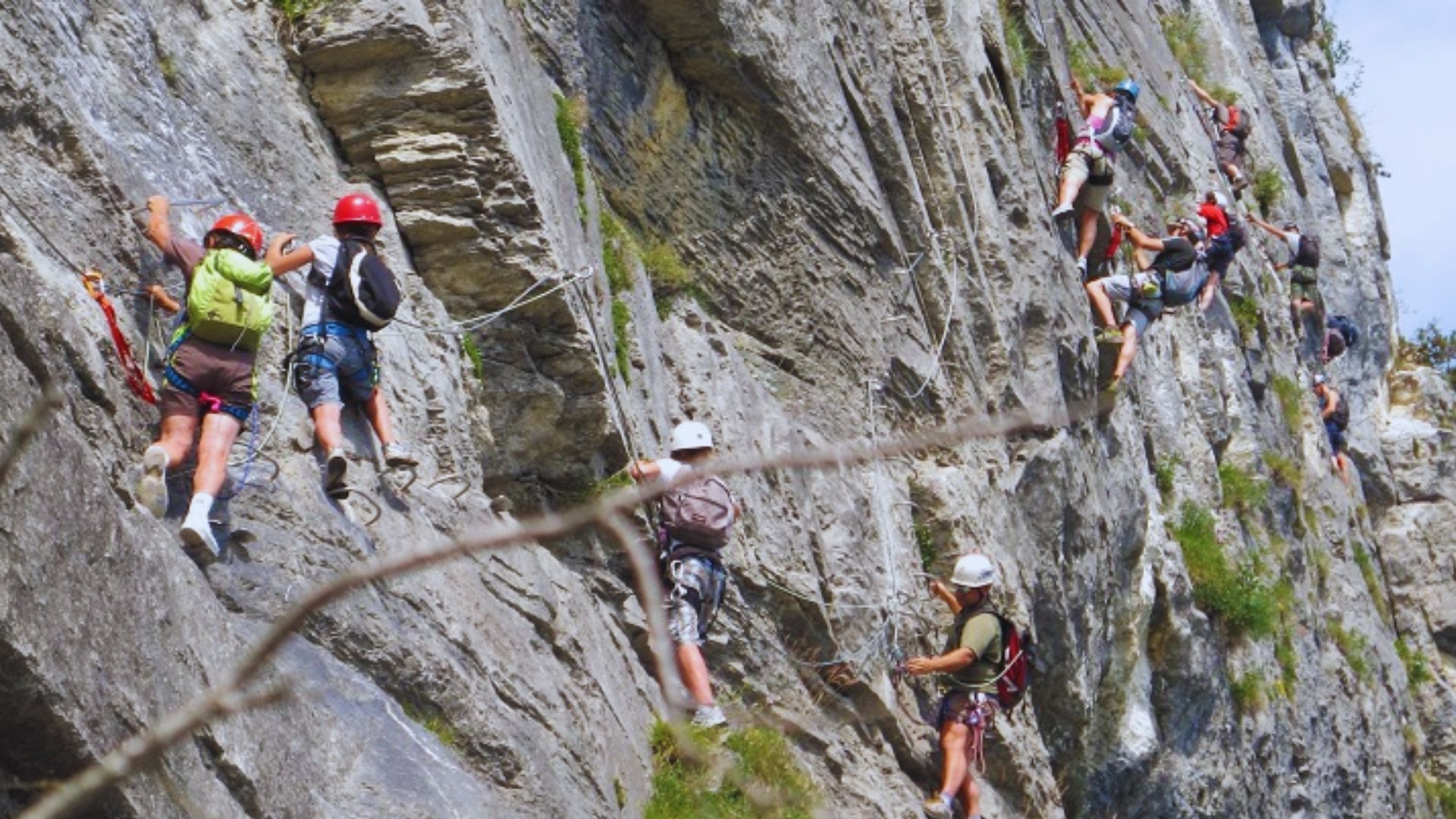 A group of climbers ascending a steep mountain, showcasing teamwork and determination against a rugged landscape.