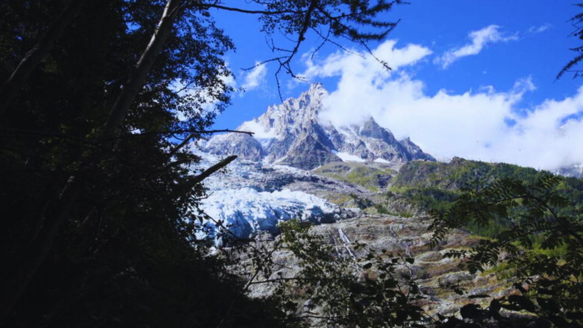 A majestic mountain with a glacier visible in the background, showcasing a stunning natural landscape.