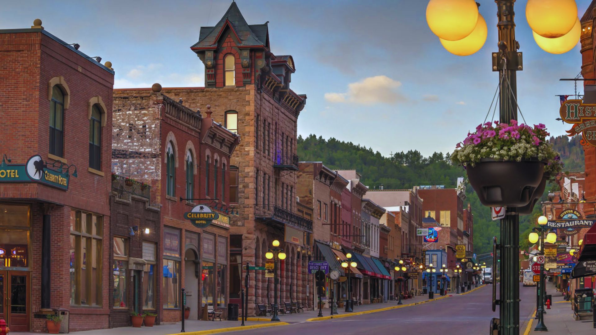 A busy street lined with various buildings and a light pole standing prominently on the sidewalk.