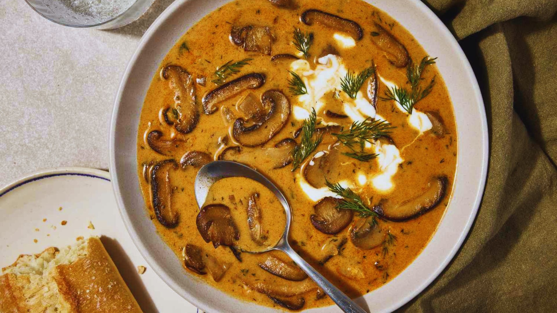 Creamy mushroom soup topped with a dollop of sour cream and sprinkled with fresh dill.
