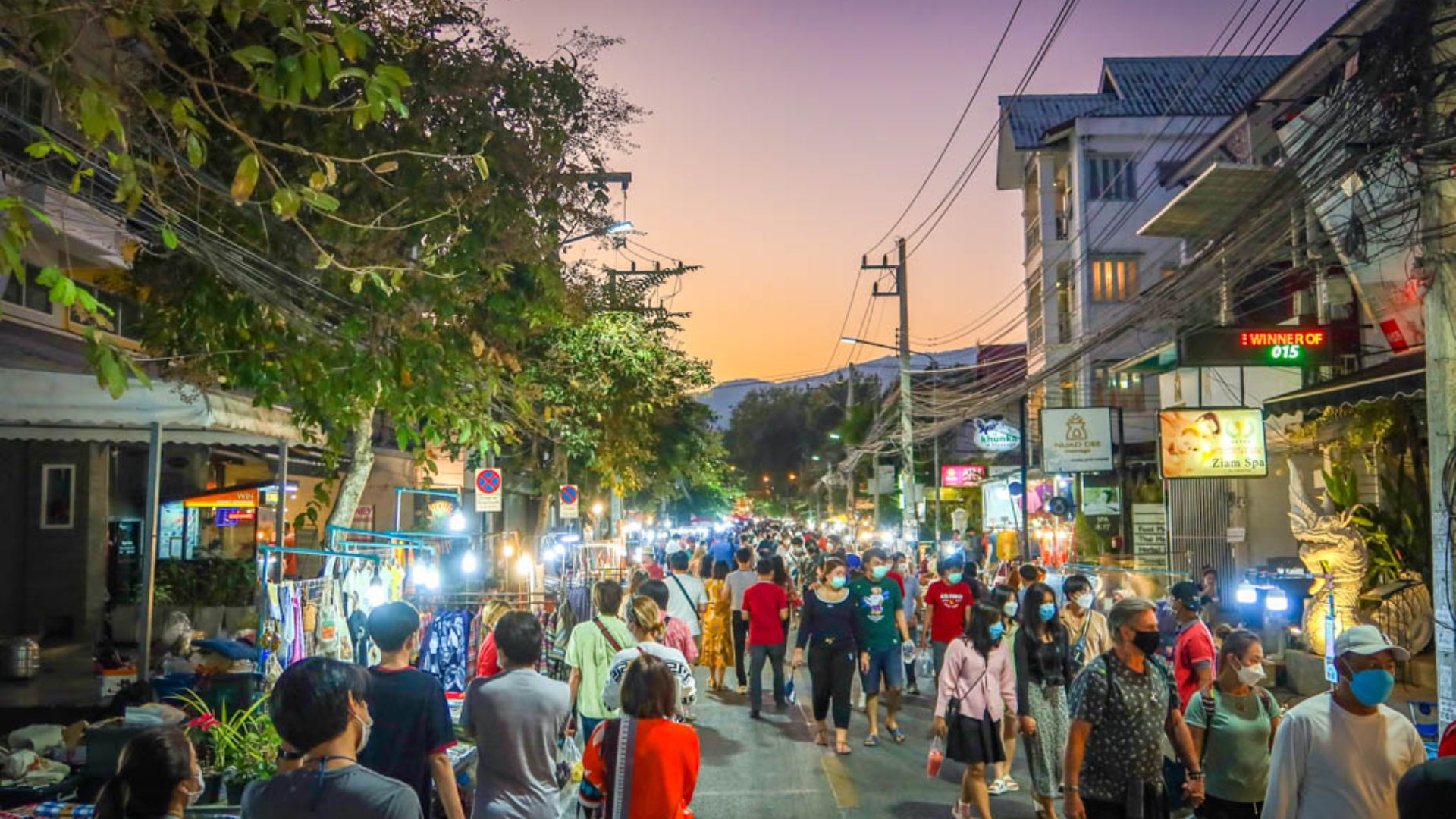 Vibrant Bangkok street scene at night, featuring neon lights, bustling vendors, and lively pedestrians.