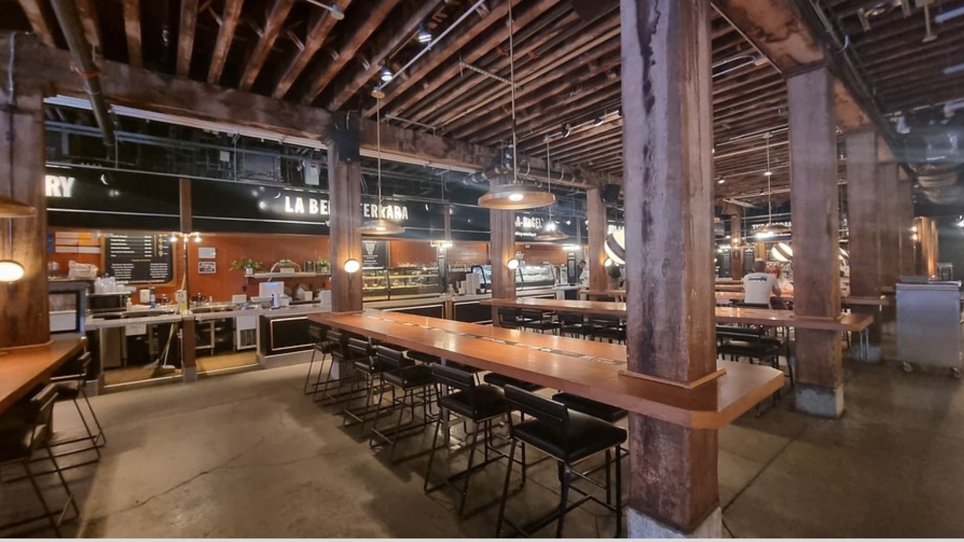Interior of a restaurant featuring wooden beams and rustic tables, creating a warm and inviting atmosphere.