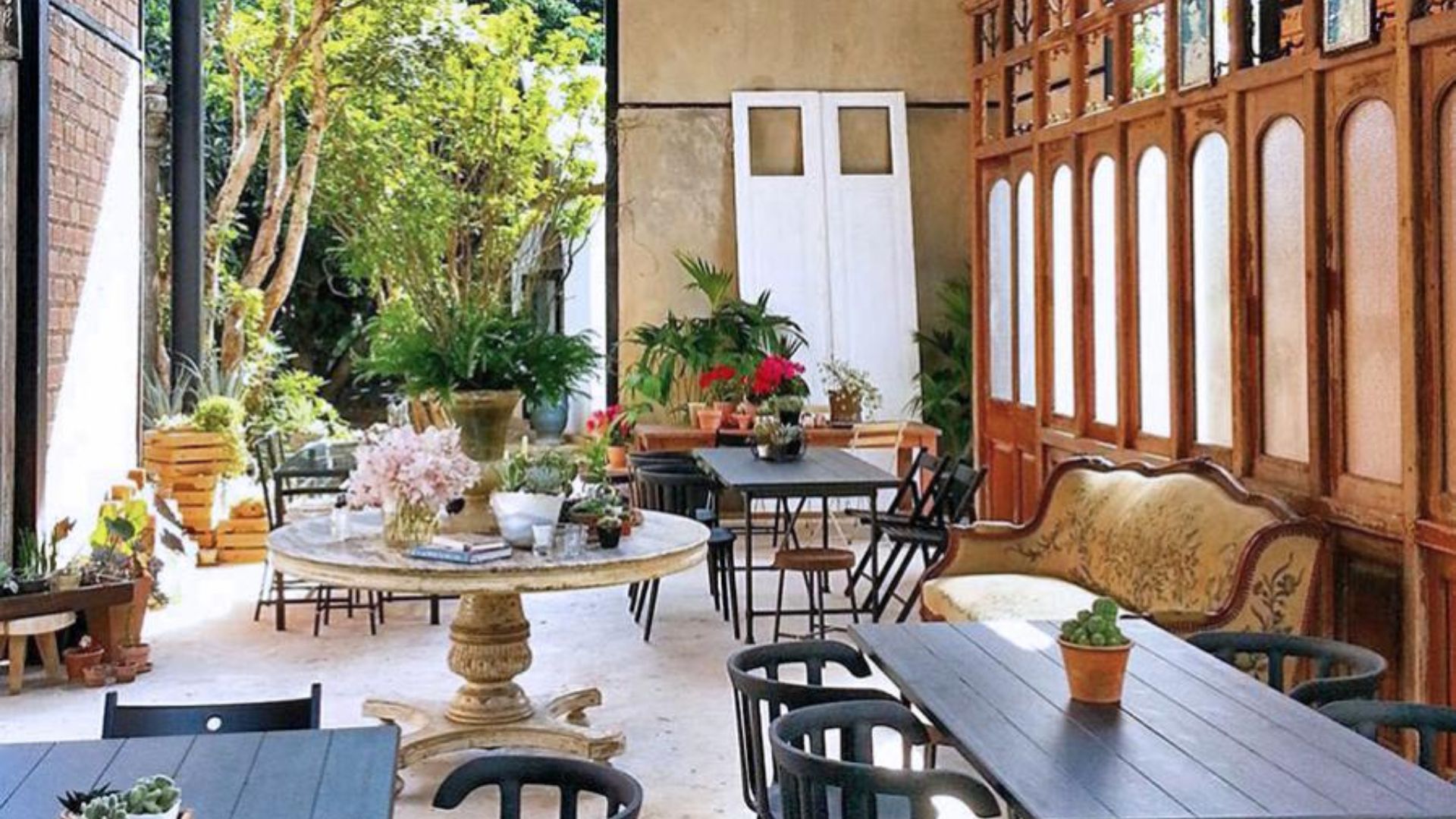 A restaurant courtyard featuring several tables and chairs arranged for outdoor dining.