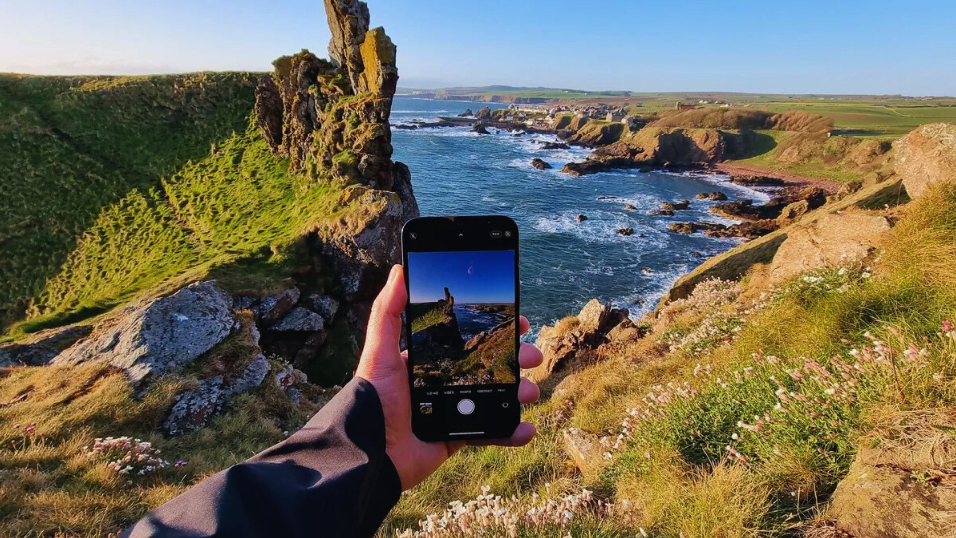 A photographer capturing the ocean and cliffs, highlighting the stunning coastal scenery.