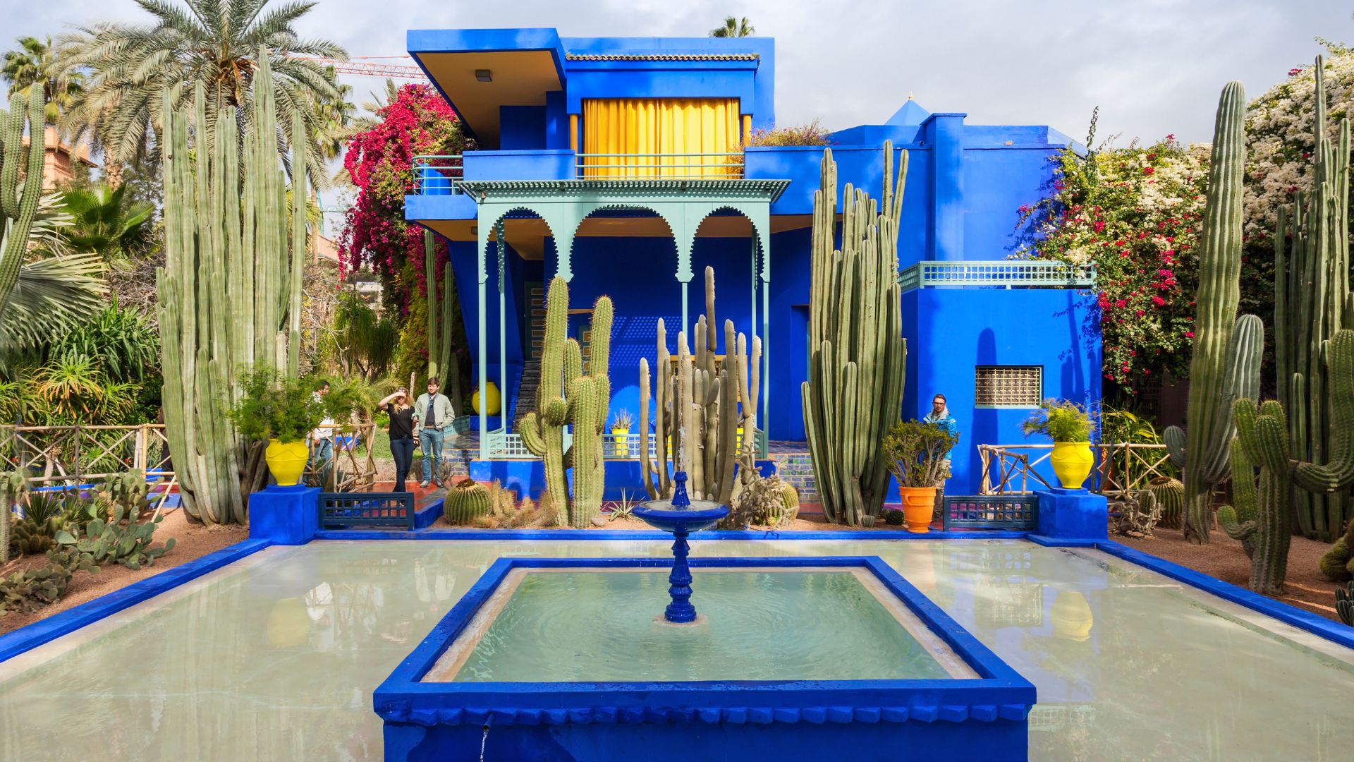 A vibrant blue house in Marrakech, Morocco, showcasing traditional architecture against a clear sky.