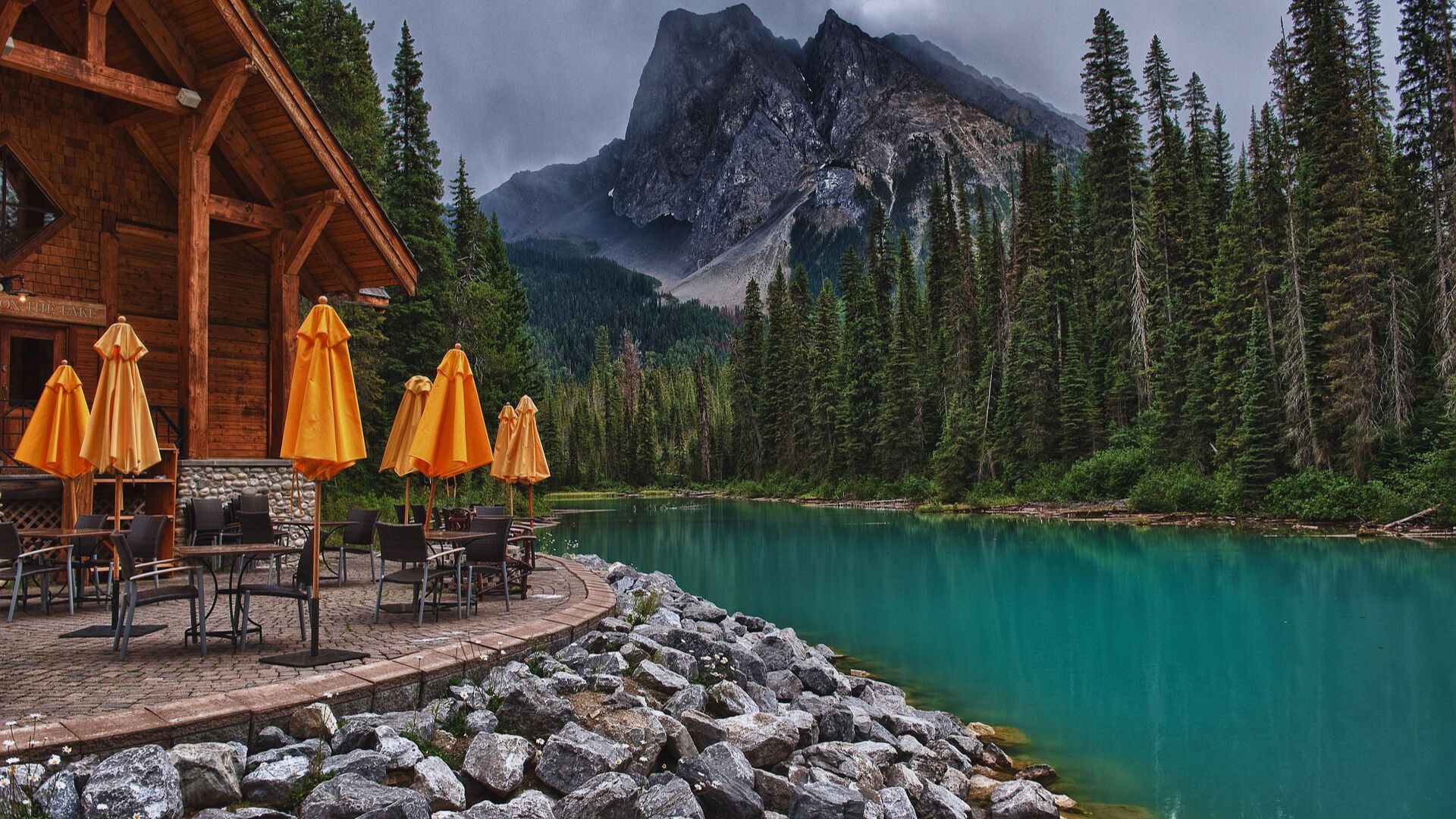 A picturesque restaurant with views of a serene lake and towering mountains, inviting guests to enjoy the landscape.