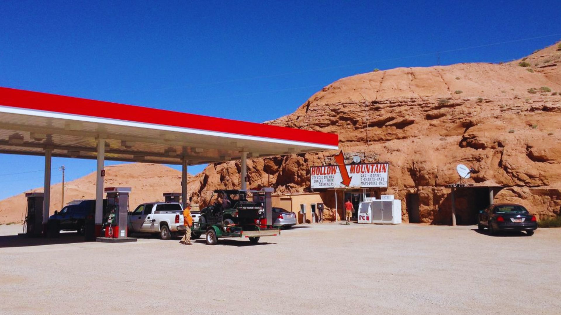 A gas station featuring a prominent red and white sign, indicating fuel services available.