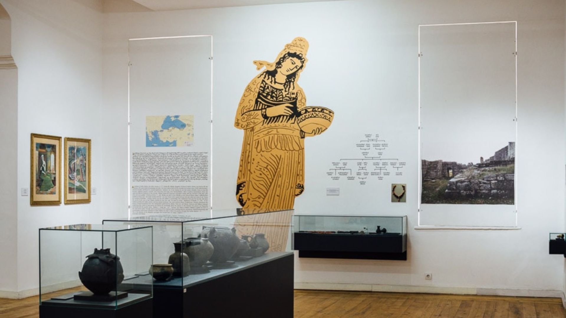 A museum interior featuring a large painting of a woman prominently displayed on the wall.