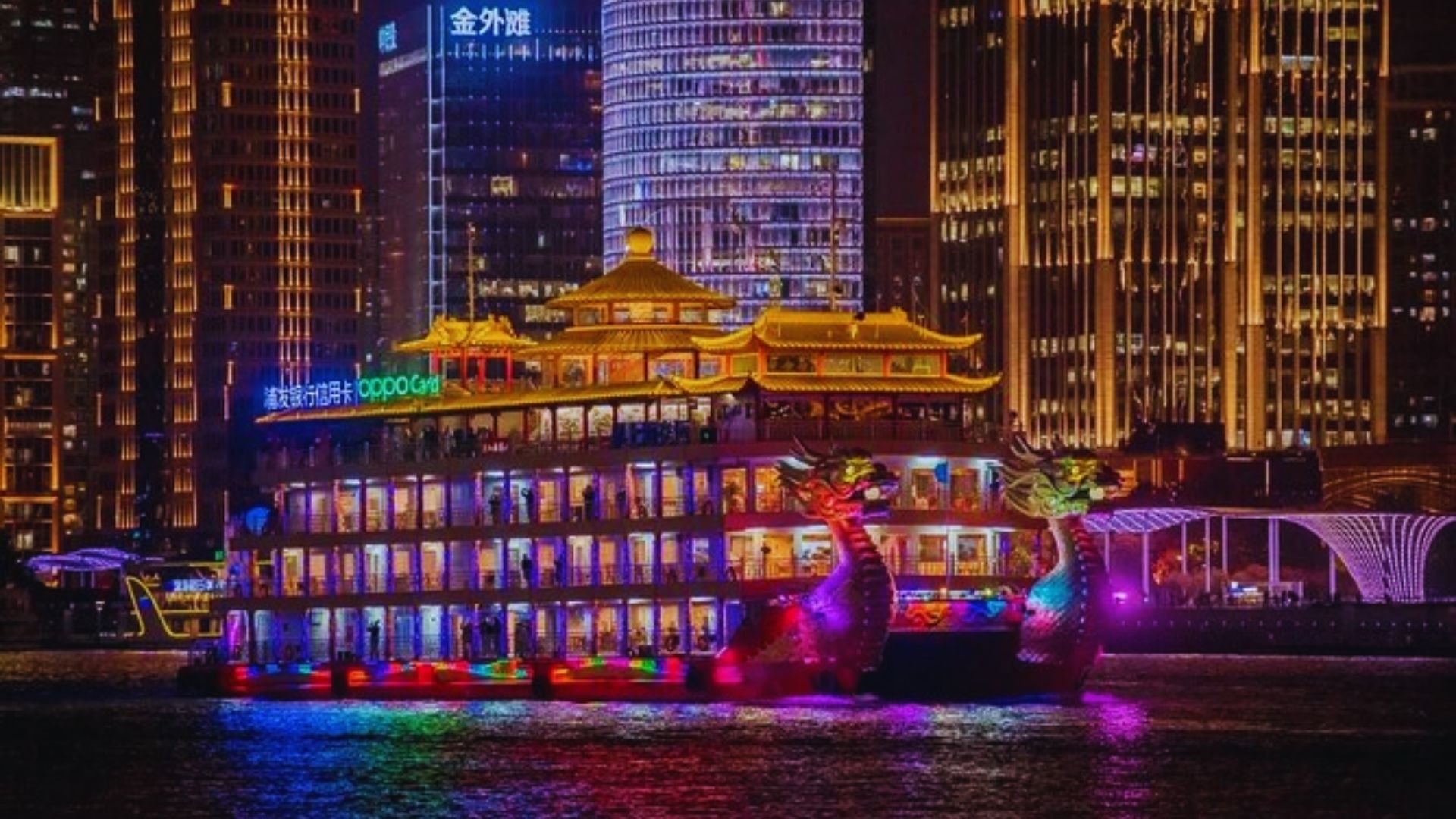 A boat adorned with colorful lights, set against a backdrop of a bustling city illuminated at night.