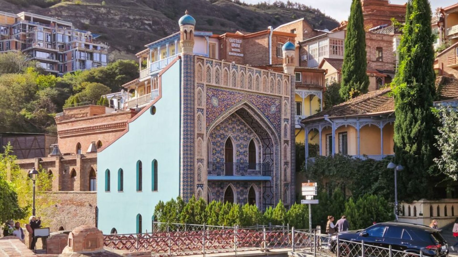 A vibrant building featuring a blue roof and a blue door, surrounded by colorful surroundings.