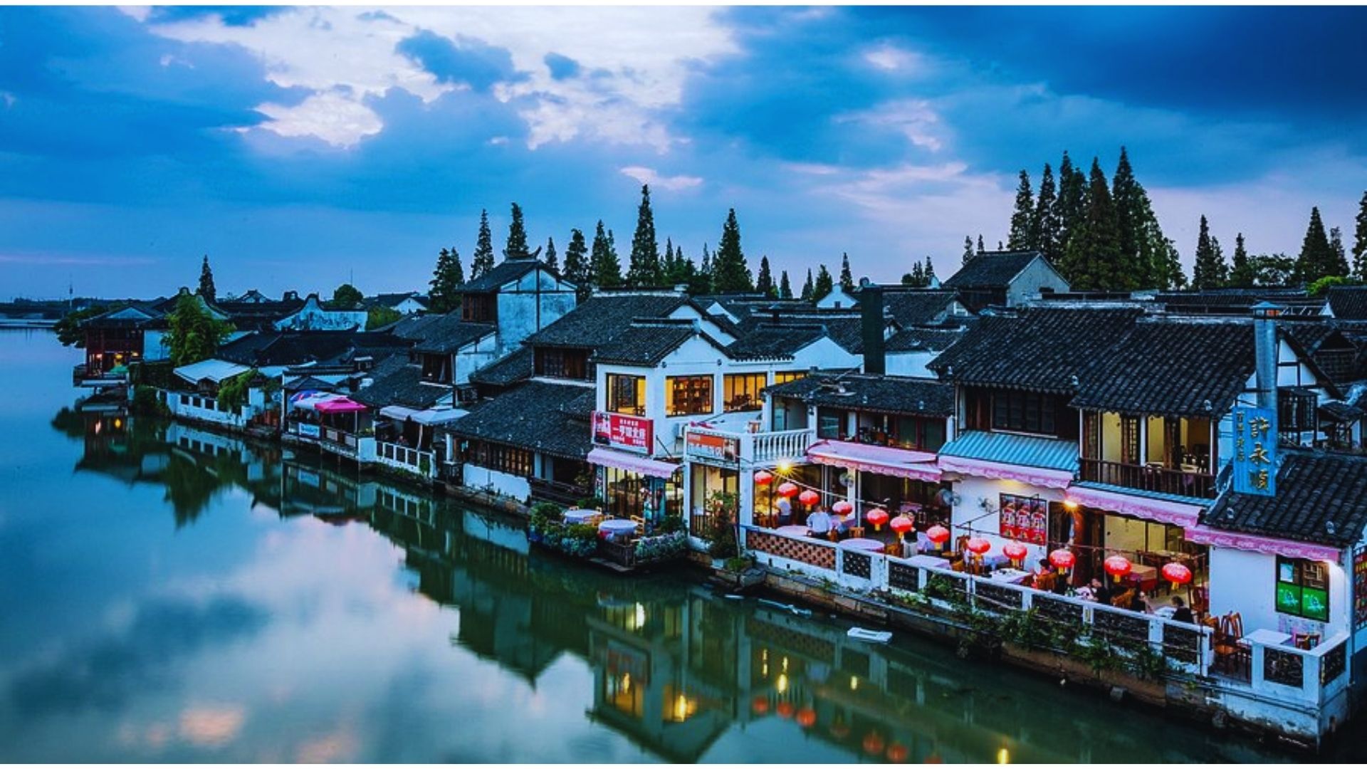 A river in China bordered by various buildings and houses, showcasing urban life along the waterway.