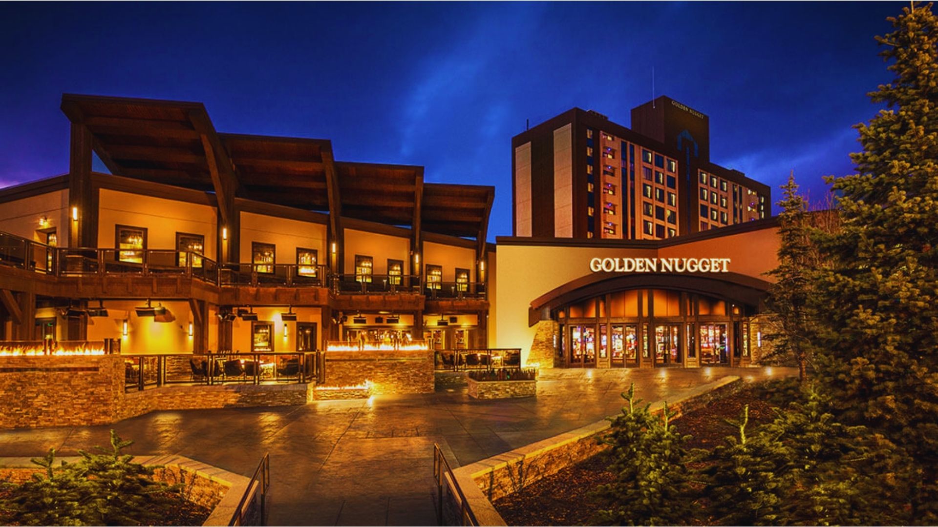 Golden Mountain Resort and Casino, featuring a luxurious building surrounded by scenic mountains and clear blue skies.