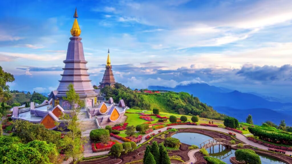 Scenic view of Wat Phra That pagoda in Thailand, surrounded by lush greenery and a clear blue sky.