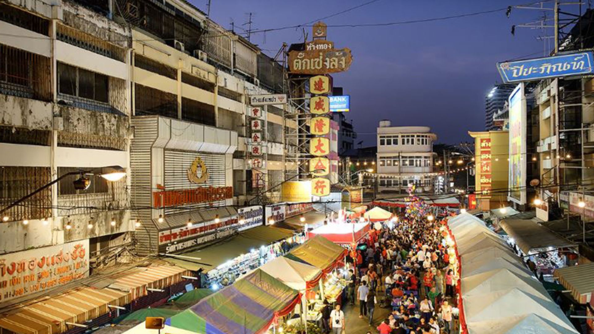 A bustling street filled with numerous people walking in various directions, creating a lively urban atmosphere.
