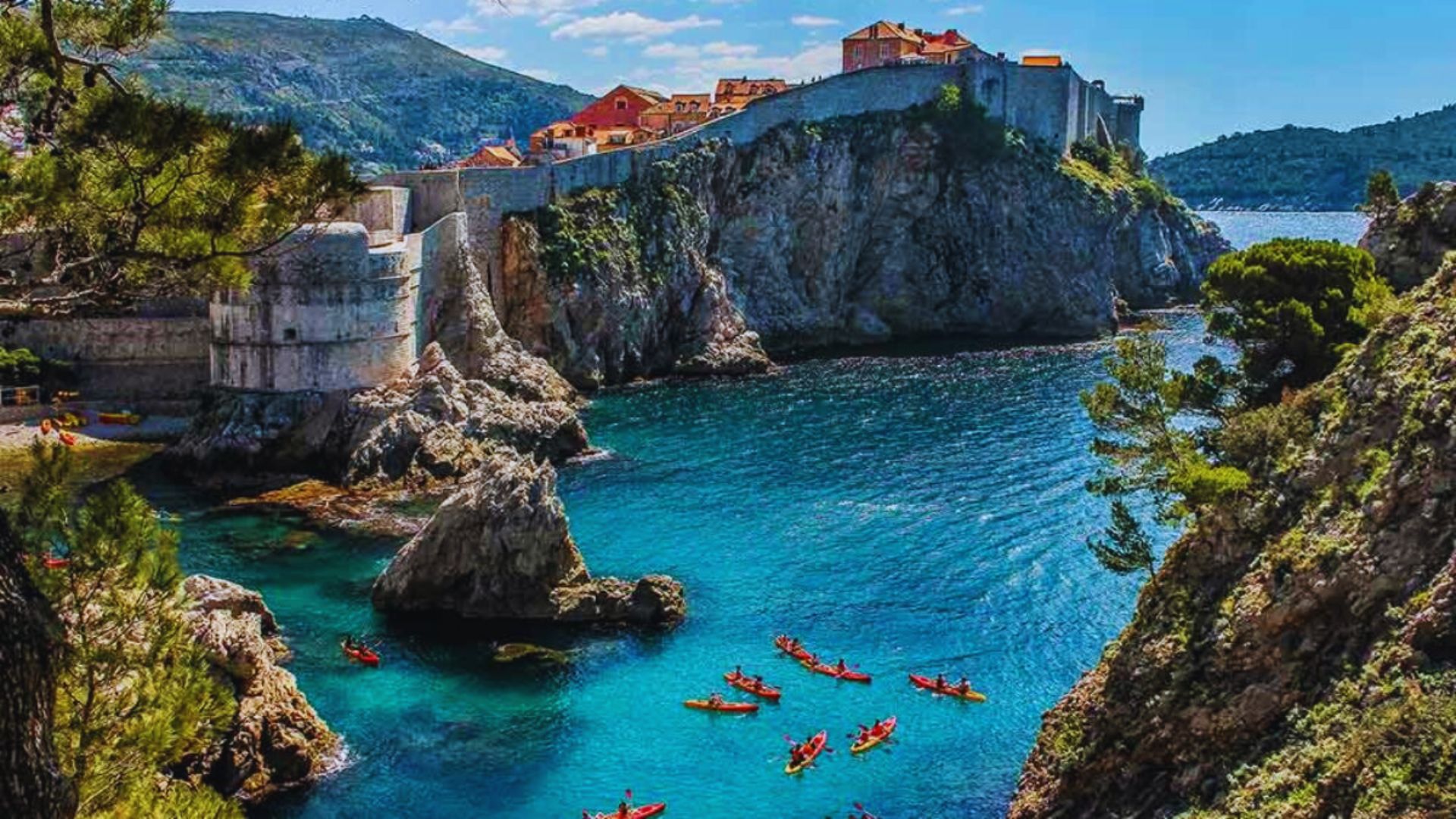 Scenic view of the stunning Croatian coast, featuring clear blue waters and rocky cliffs under a bright sky.