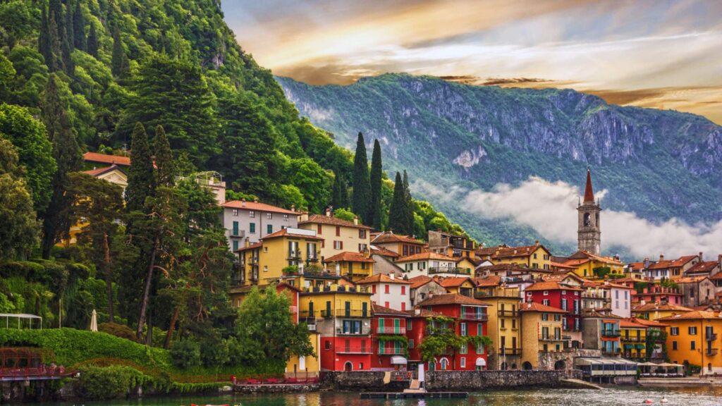 Colorful houses line the shore of Lake Como, Italy, reflecting vibrant hues against the serene water.