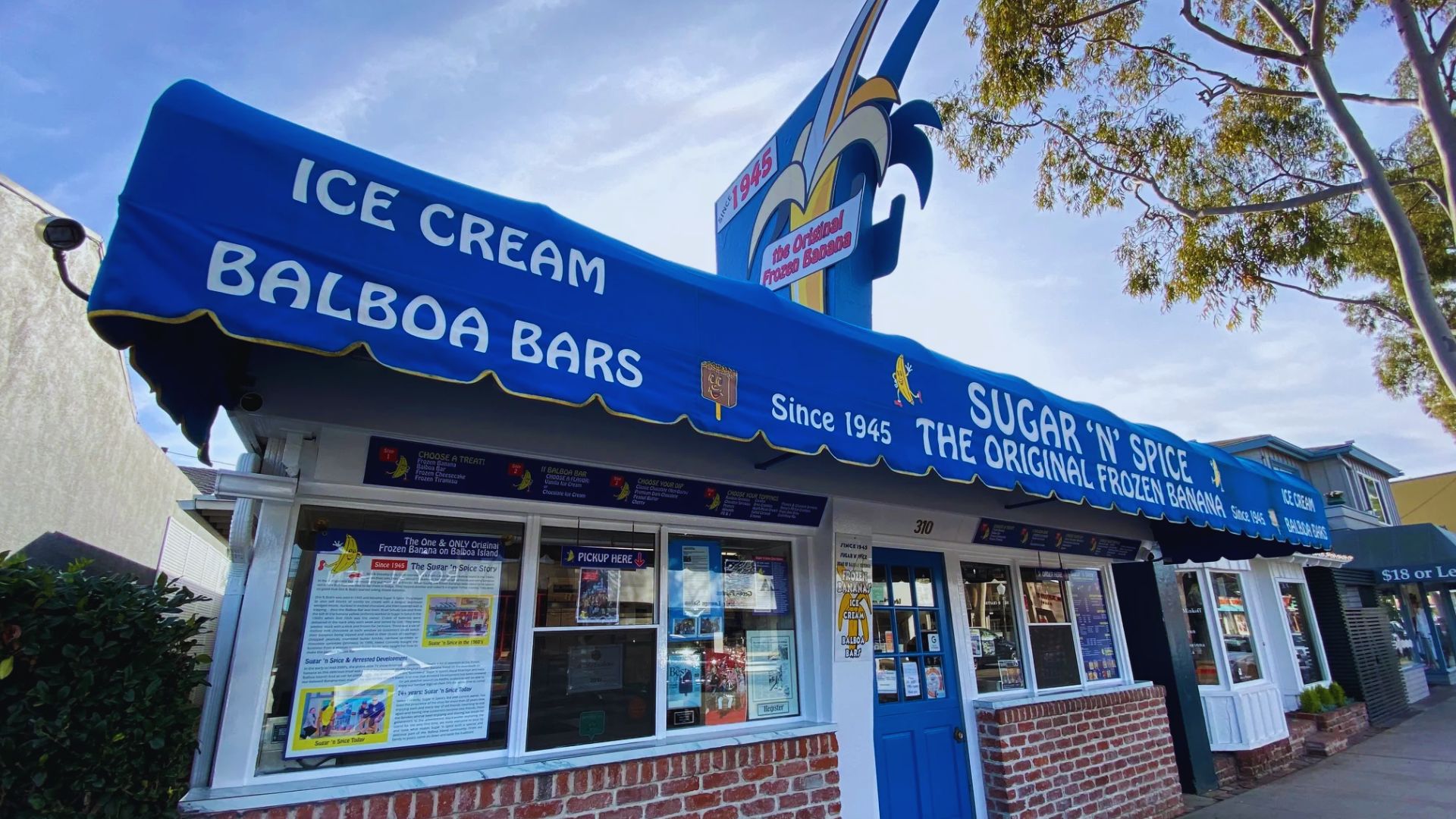 Ice cream shop featuring a blue awning and a sign that reads "Ice Cream" prominently displayed above the entrance.