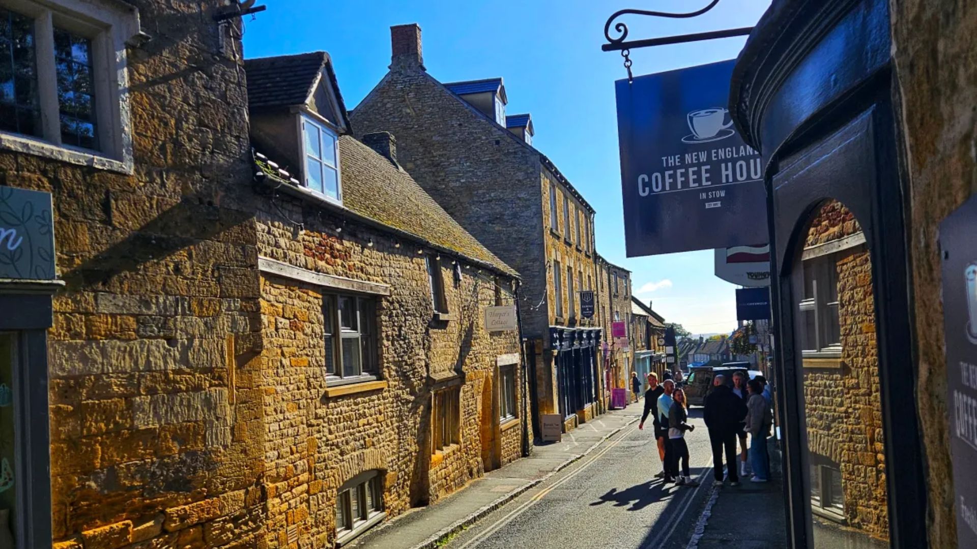 A lively narrow street with various people walking, creating a vibrant urban scene.