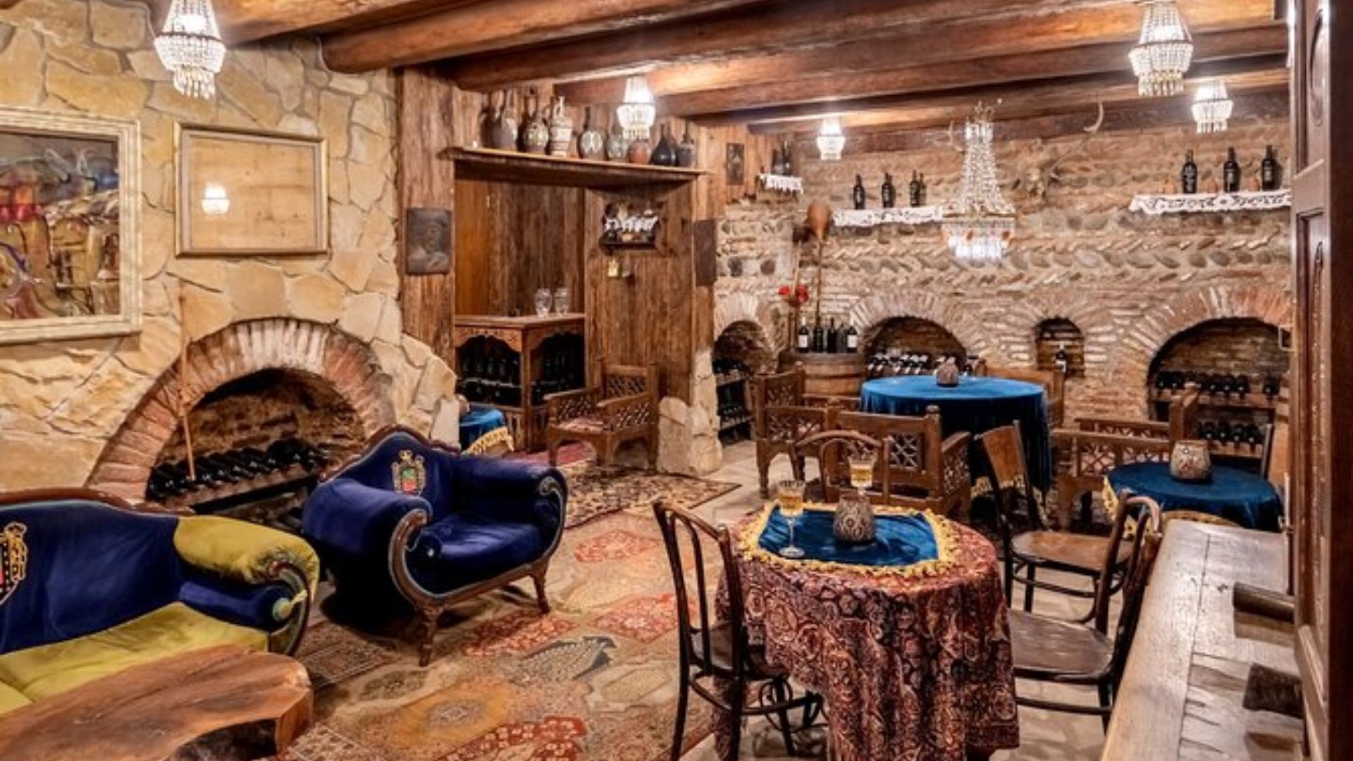 A room featuring a rustic stone wall and a warm wooden ceiling, creating a cozy and inviting atmosphere.