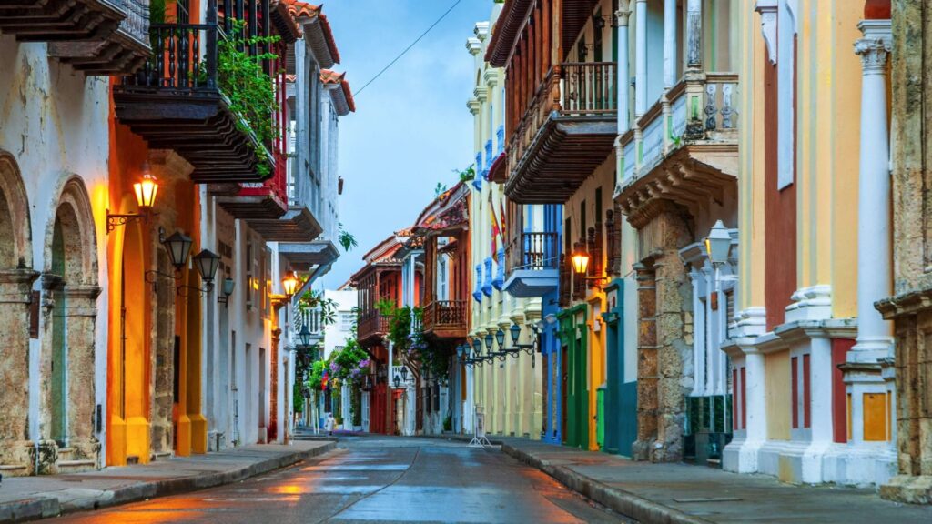 A vibrant street in Cartagena, Cuba, showcasing colorful buildings under a clear blue sky.