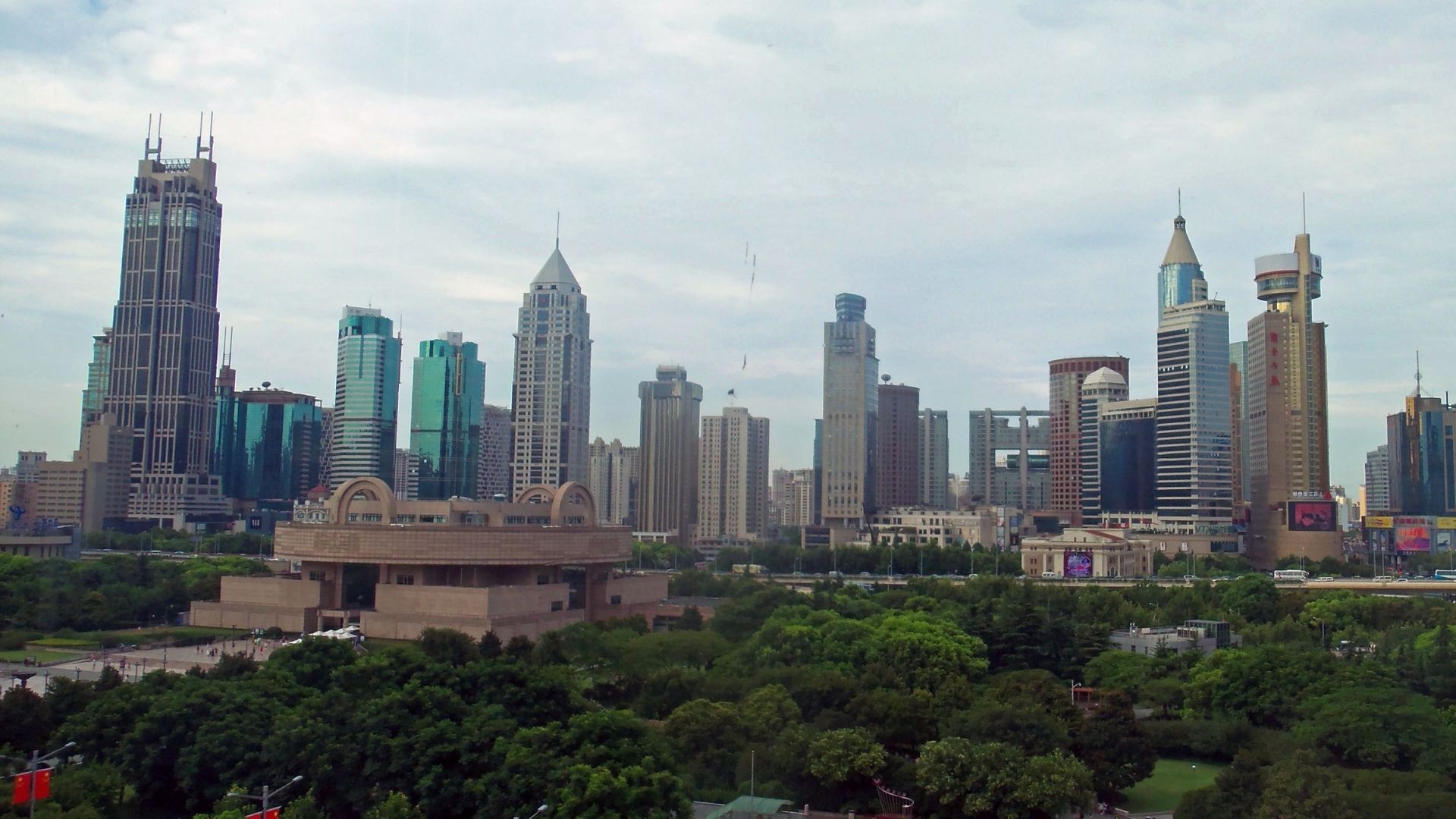 A panoramic view of the city skyline from a tall building, showcasing skyscrapers against a clear blue sky.