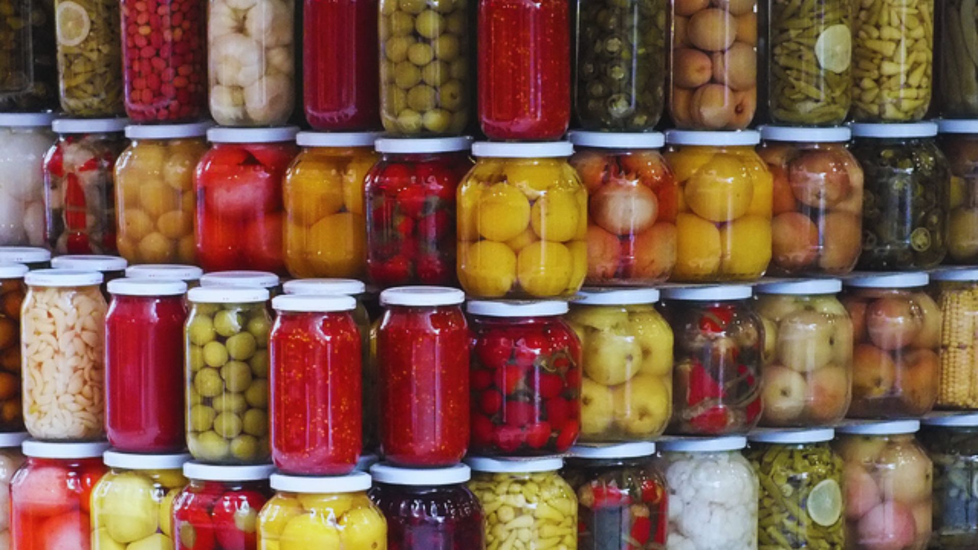 A collection of stacked jars filled with colorful pickled vegetables, showcasing various types and sizes.A collection of stacked jars filled with colorful pickled vegetables, showcasing various types and sizes.